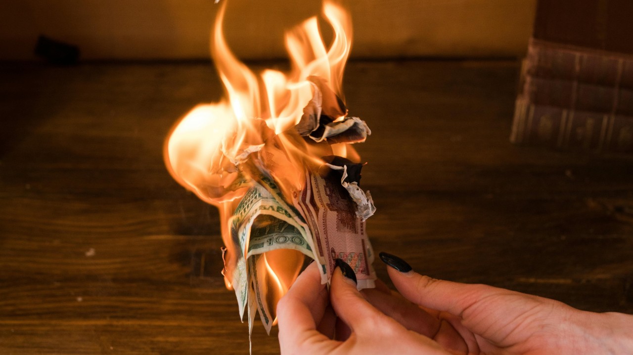 A close-up photo of someone holding cash on-fire